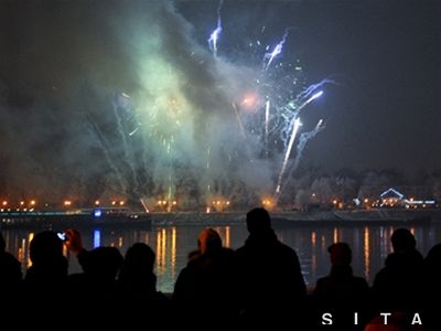 Ľudia sledujú ohňostroj na druhej strane rieky Dunaj.