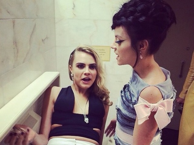 Cara Delevingne (vľavo) si urobila pohodlie na záchode. Vpravo stojí Lily Allen