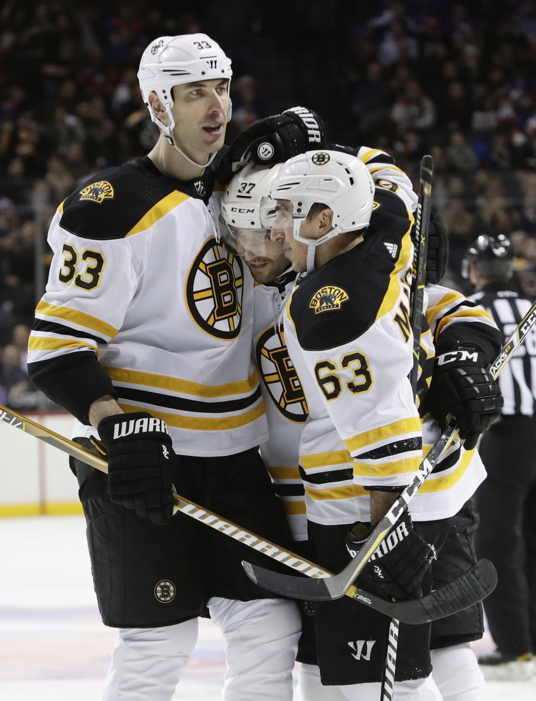 Zdeno Chára (33) a Brad Marchand (63) oslavujú gól Patrica Bergerona do siete NY Islanders.
