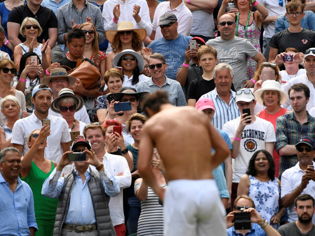 Ženská časť publika tlieska počas chvíle, keď si španielsky hráč Rafael Nadal prezlieka tričko v prestávke zápasu na Wimbledone. 
