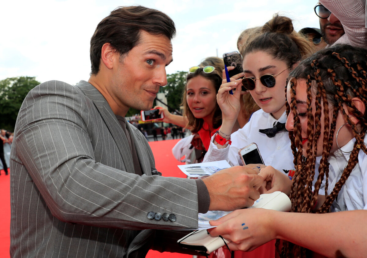 Herec Henry Cavill podpisuje karty od fanúšikov. 