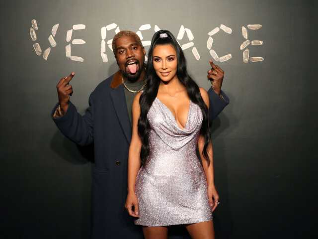 Manželia Kanye West a Kim Kardashian pózujú fotografom pred prehliadkou Versace. 