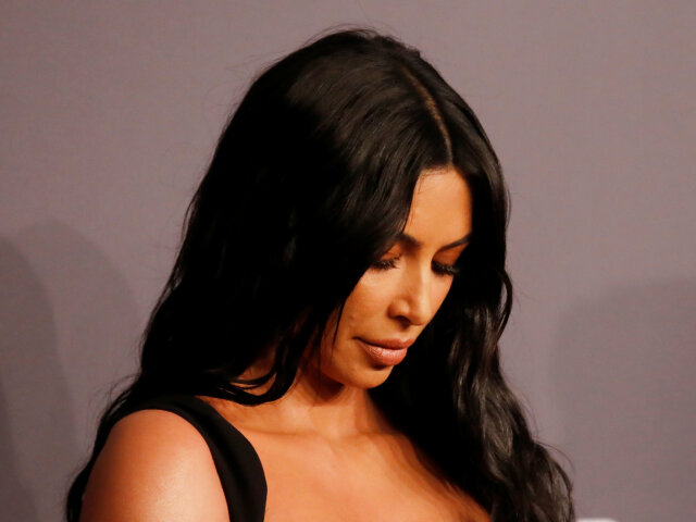 Kim Kardashian si kontroluje svoje poprsie v odvážnych šatách Versace.