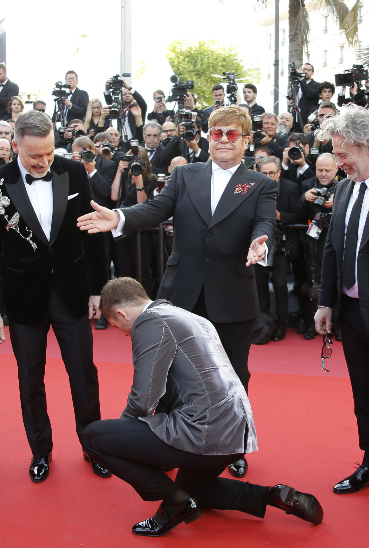 Elton John (v strede) a pri jeho nohách herec Taron Egerton