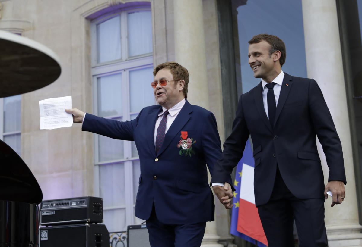 Francúzsky prezident Emmanuel Macron (vpravo) drží za ruku speváka - Sira Eltona Johna pred príhovorom, ktorý dvojica absolvovala v Elyzejskom paláci. 