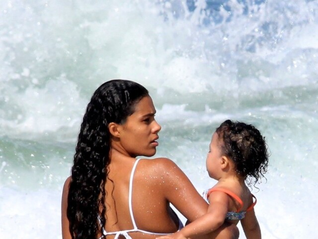 Brazílska modelka Tina Kunakey na pláži v Brazílii s dcérkou Amazonie na rukách.