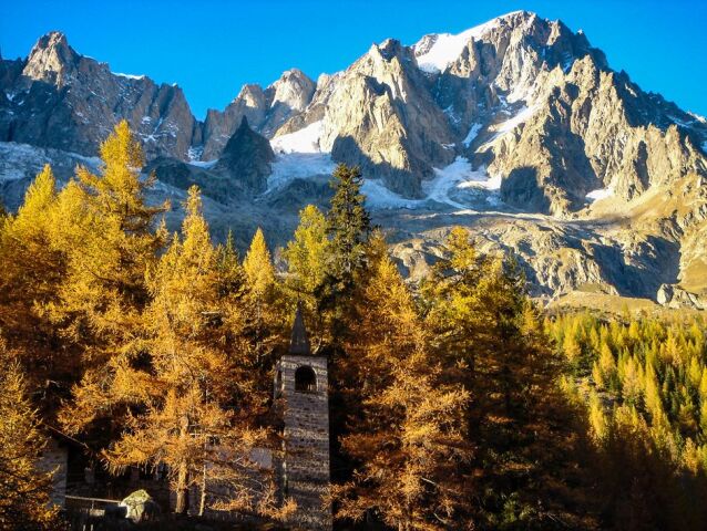            The church of the Planpinicieux village in the Italian Val Ferret, with the Grandes Jorasses peak on the top right and the Planpincieux Glacier on the top left                   