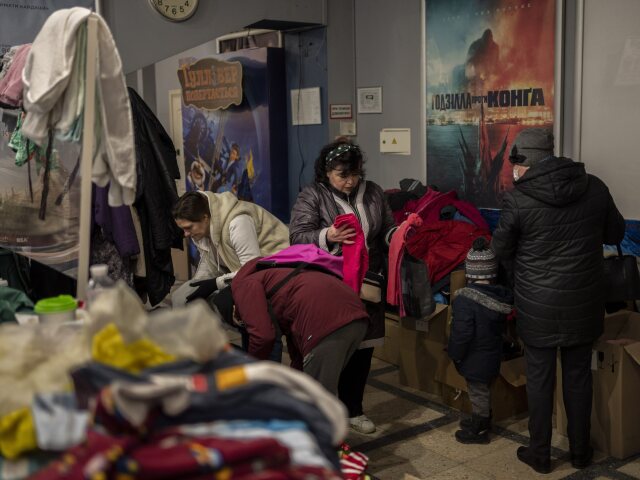 Ukrajinky si vyberajú ošatenie v kine, ktoré slúži ako humanitátne centrum v meste Ľvov na západe Ukrajiny počas 17. dňa ruskej invázie na Ukrajine v sobotu 12. marca 2022.
