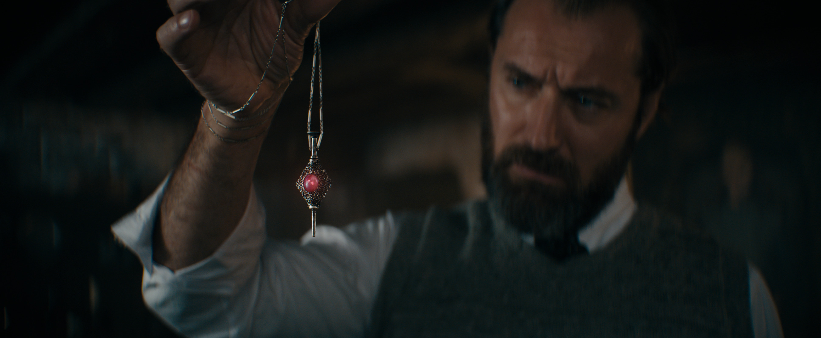 Dumbledore a jeho magický prívesok, kvôli ktorému nesmie zaútočiť priamo na Grindelwalda. Záber z filmu Fantastické zvery: Tajomstvá Dumbledora.