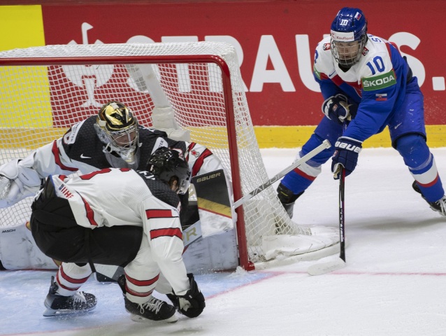 Adam Sýkora (Slovensko), uprostred Travis Sanheim a brankár Logan Thompson