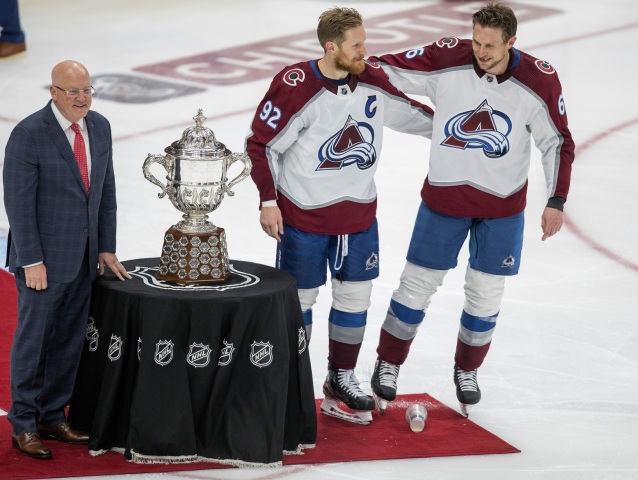 Gabriel Landeskog (s šíslom 92) a Erik Johnson so zástupcom komisára NHL Billom Daleym pri trofeji pre víťaza Západnej konferencie.