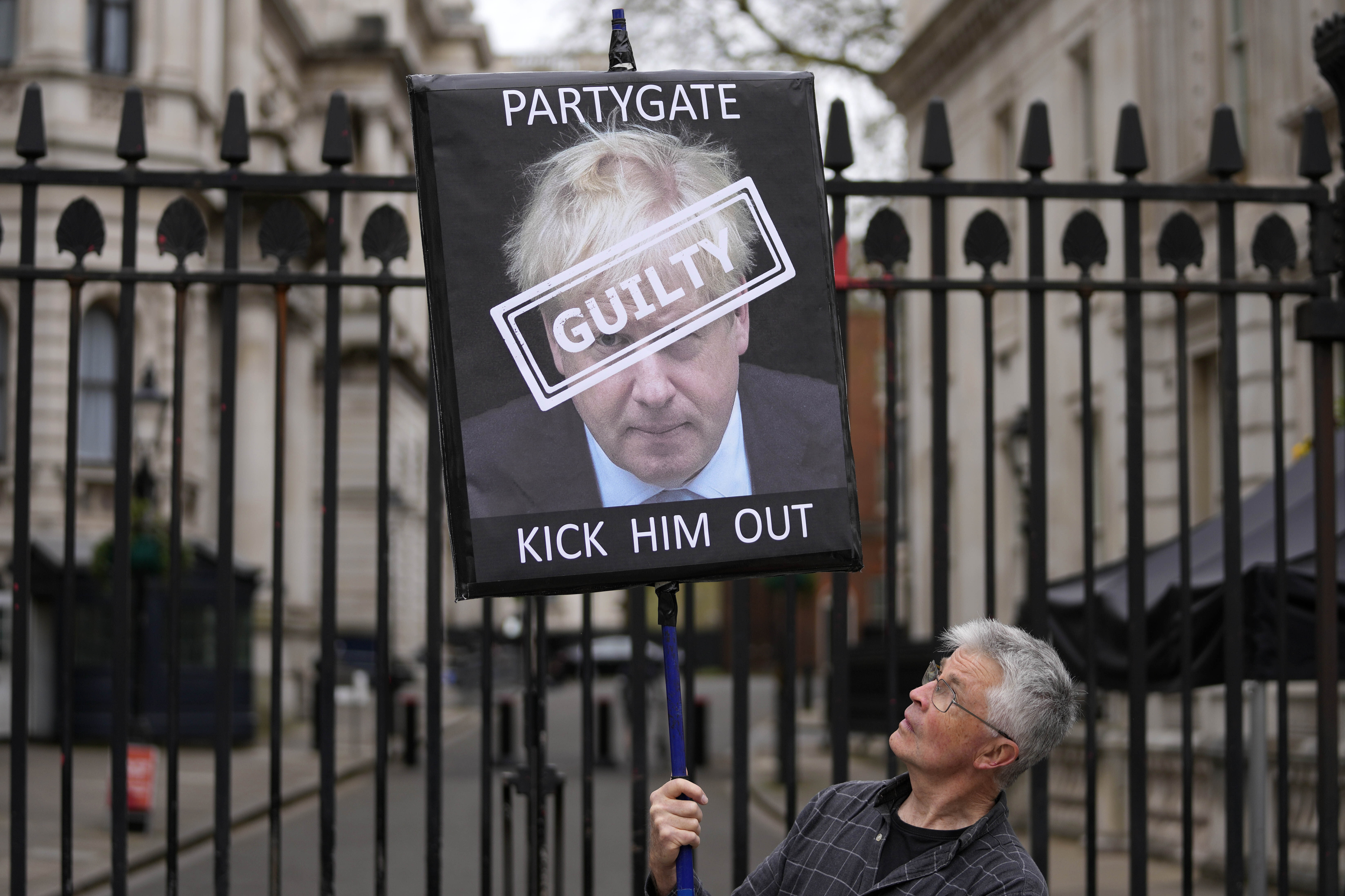 Demonštrant drží nápis zobrazujúci britského premiéra Borisa Johnsona pred vchodom na Downing Street v Londýne.