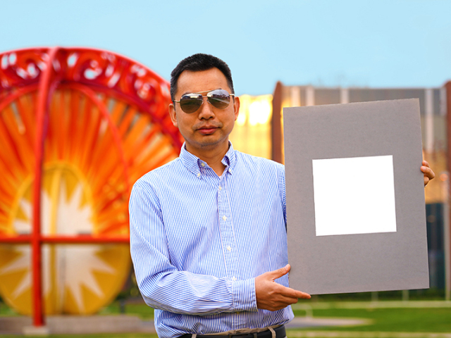 Xiulin Ruan, a Purdue University professor of mechanical engineering, holds up his labâ€™s sample of the whitest paint on record. (Purdue University/Jared Pike)