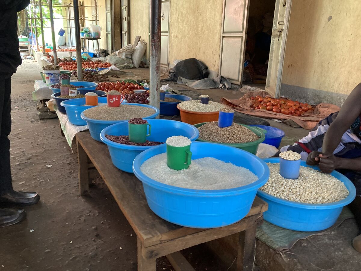 NEPOUZ, Uganda, Na trhu sa predavaju rozne potraviny. Mierkou je poharik