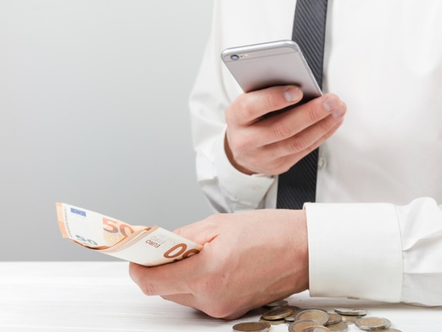 man-holding-money-using-calculator, pr, nepouzivat