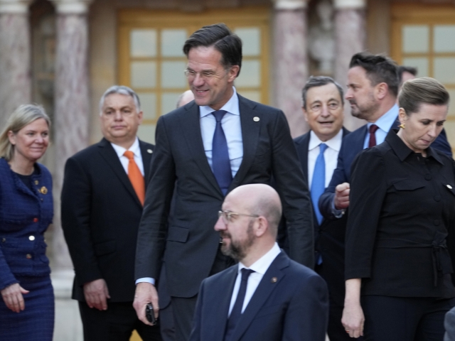 Holandský premiér Mark Rutte stojí uprostred hlúčika kolegov na summite EÚ, naľavo od neho je predseda maďarskej vlády Viktor Orbán.