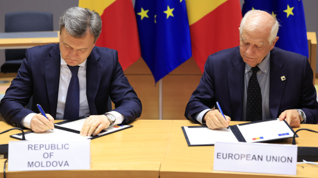 Šéf zahraničnej politiky Európskej únie Josep Borrell (vpravo) a moldavský premiér Dorin Recean podpisujú v Bruseli dohodu o obrannom partnerstve medzi EÚ a Moldavskom v utorok 21. mája 2024.