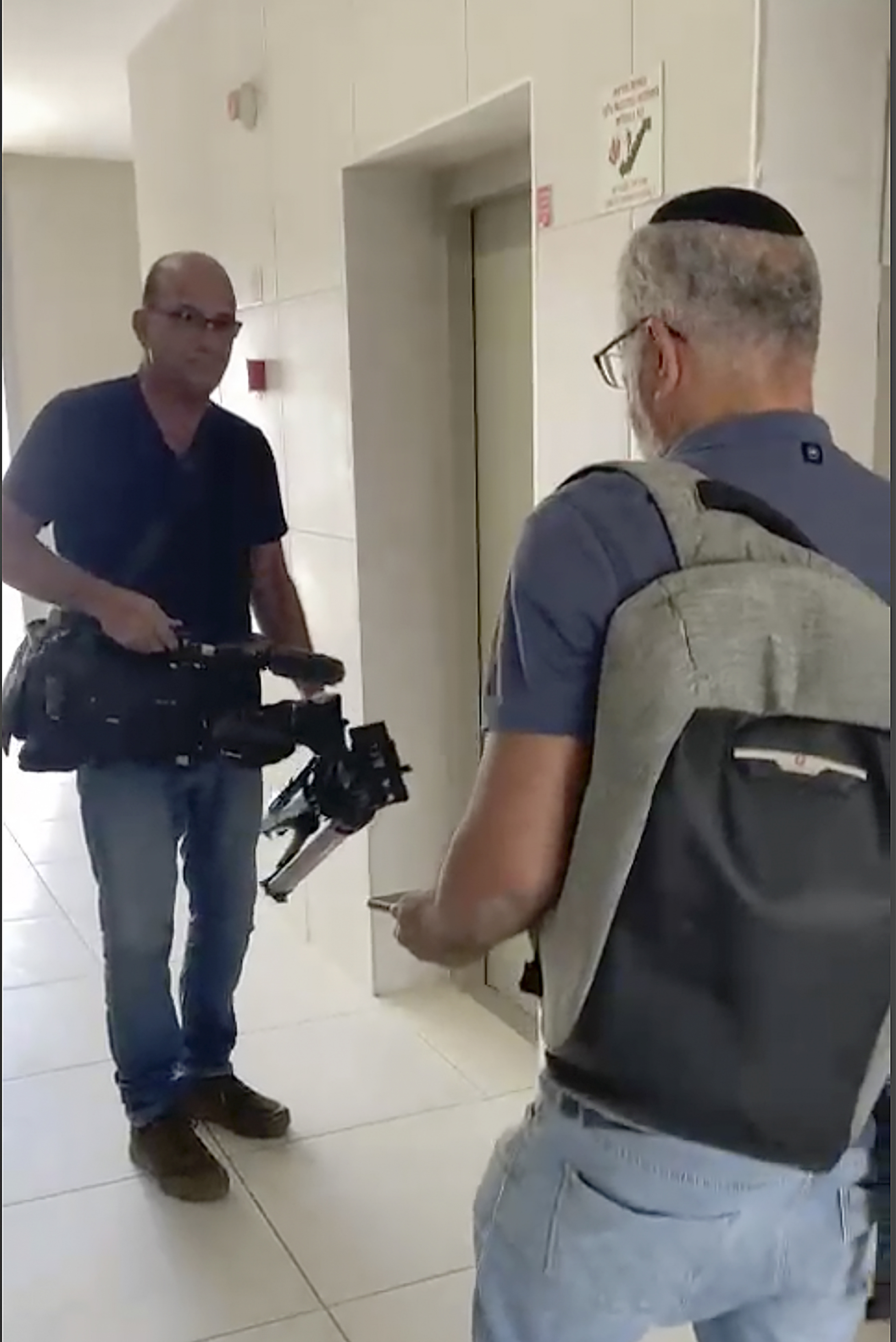 Na snímke z videozáznamu izraelskí úradníci práva zahabujú videozariadenie agentúry AP v obytnom komplexe v meste Sderot v utorok 21. mája 2024.