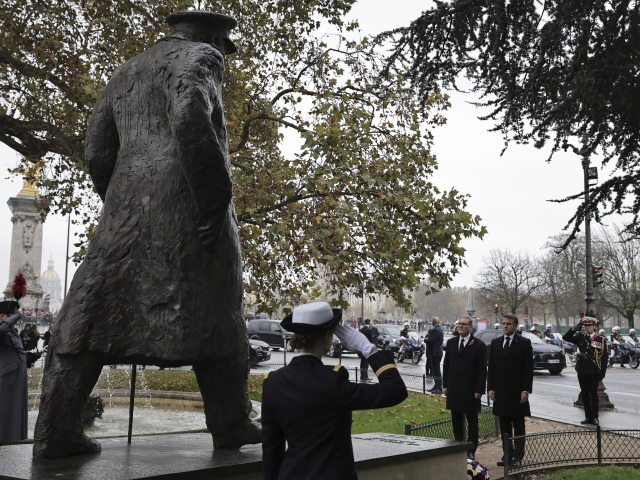 Francúzsky prezident Emmanuel Macron (vpravo) a britský premiér Keir Starmer pred sochou Winstona Churchilla blízko Champs Elysées avenue v Paríži (11. novembra 2024) počas ceremónie ku koncu Prvej svetovej vojny.