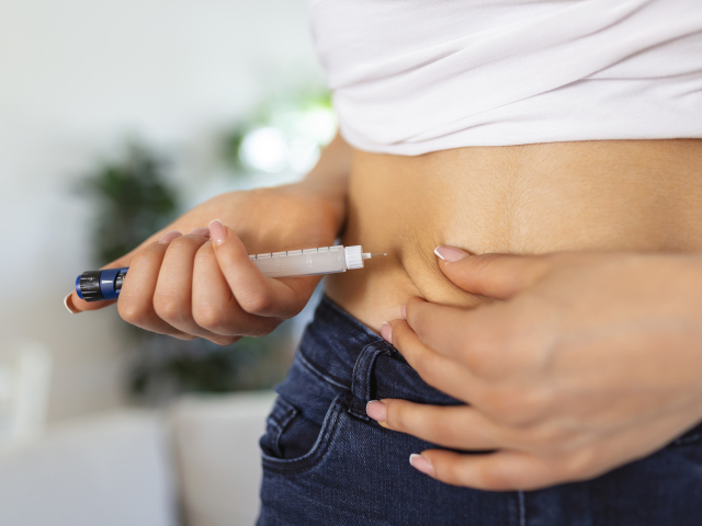A diabetic patient using insulin pen for making an insulin injection at home. Young woman control diabetes. Diabetic lifestyle