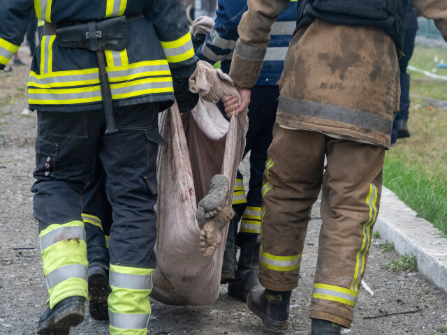 Záchranári odnášajú mŕtve telo v Charkove 18. augusta 2025 po útoku ruskej rakety na obytný dom. (AP Photo/Andrii Marienko)