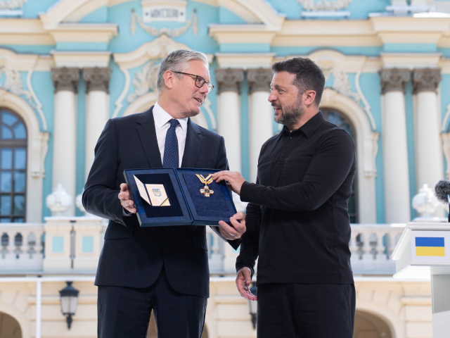Ukrajinský prezident Volodymyr Zelenskyj (vpravo) odovzdáva Rad slobody britskému premiérovi Keirovi Starmerovi v záhradách Prezidentského paláca v Kyjeve.