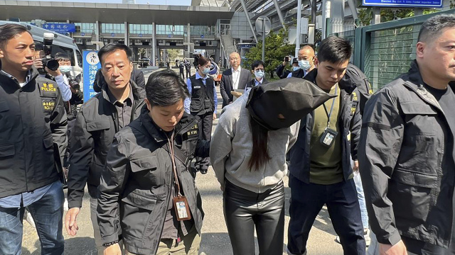 Polícia eskortuje podozrivého z vraždy modelky Abby Choi.