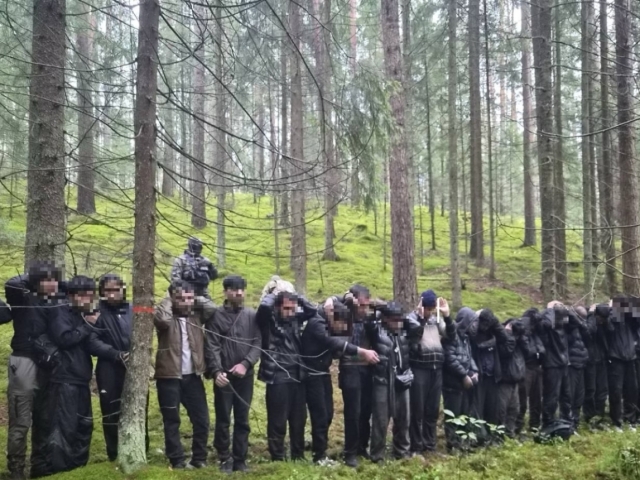 Migranti zadržaní lotyšskou pohraničnou strážou po nelegálnom prekročení hranice z Bieloruska cez podzemný tunel 20. augusta 2026.