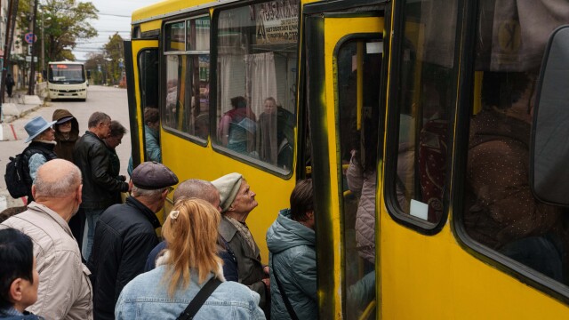 Ľudia nastupujú do autobusu počas miestneho prímeria, ktoré súvisí s úsilím o evakuáciu obyvateľov mesta Olešky.